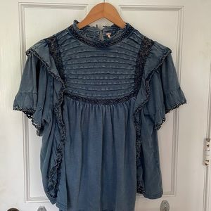 Free People pullover top. Washed denim blue jersey. Ruffles, lace and pin tucks.